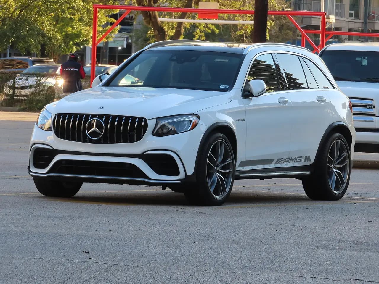 White pre-facelift Mercedes-AMG GLC 63 (X253) SUV, front three-quarter view in a car park