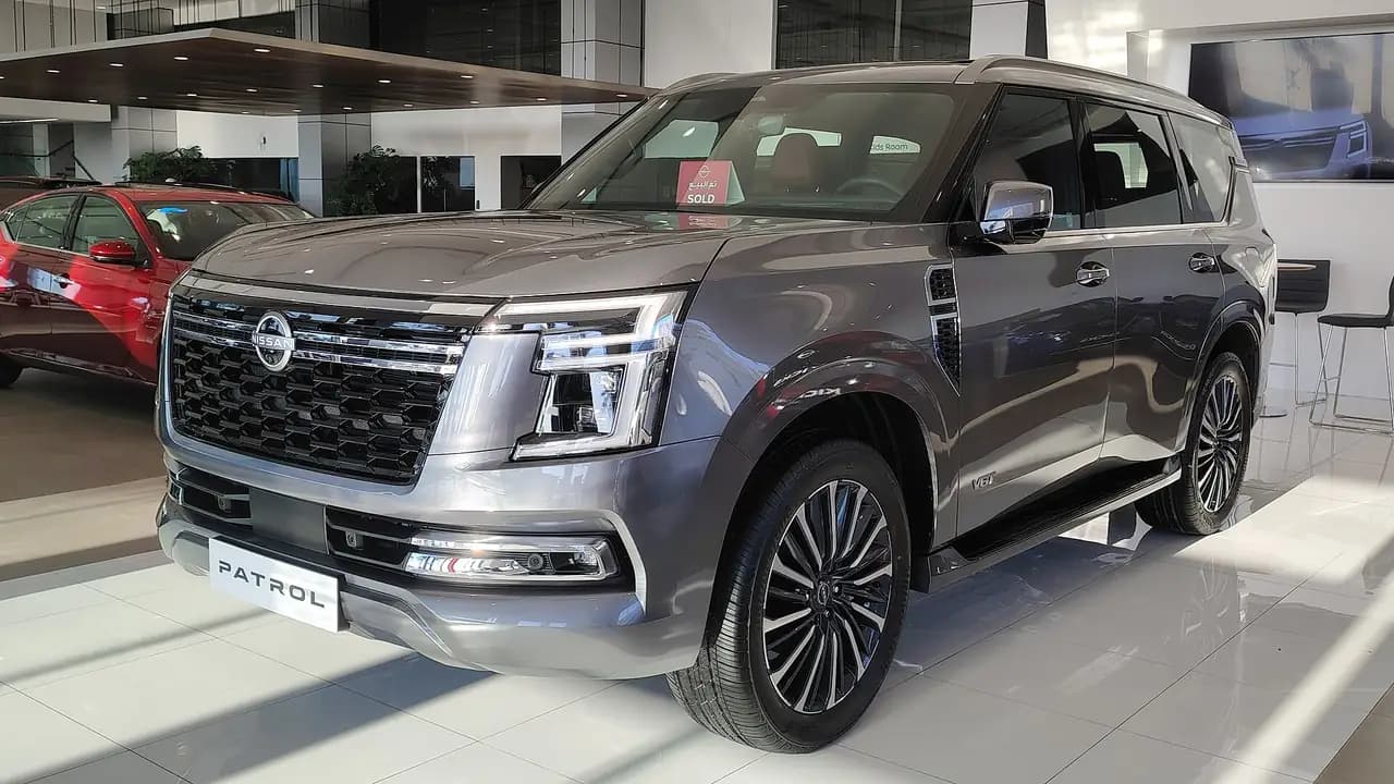 Grey 2025 Nissan Patrol LE Platinum V6T (Y63) in a showroom, front three-quarter view