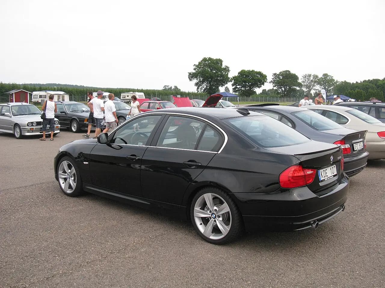 Black 2010 BMW 335i sedan (E90 LCI), rear three-quarter view