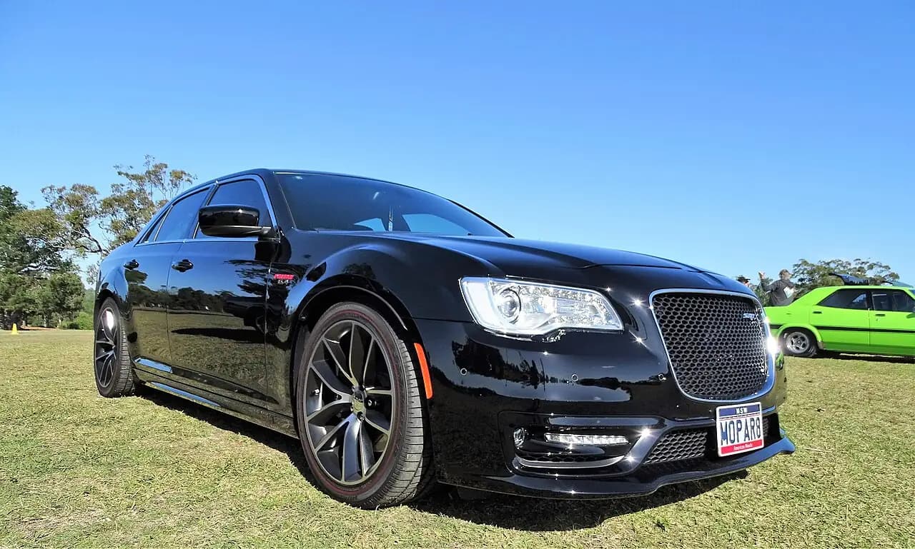 Black Chrysler 300 SRT (LD facelift) sedan, low front three-quarter view on grass