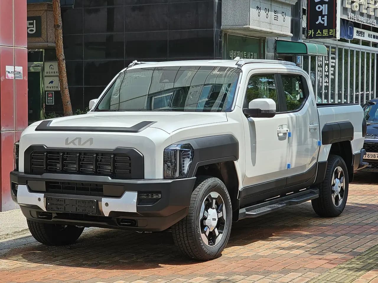 White 2025 Kia Tasman (TK) dual-cab pickup, front three-quarter view