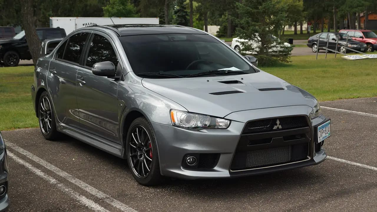 Grey Mitsubishi Lancer Evolution X (CZ4A) sedan with black roof, front three-quarter view