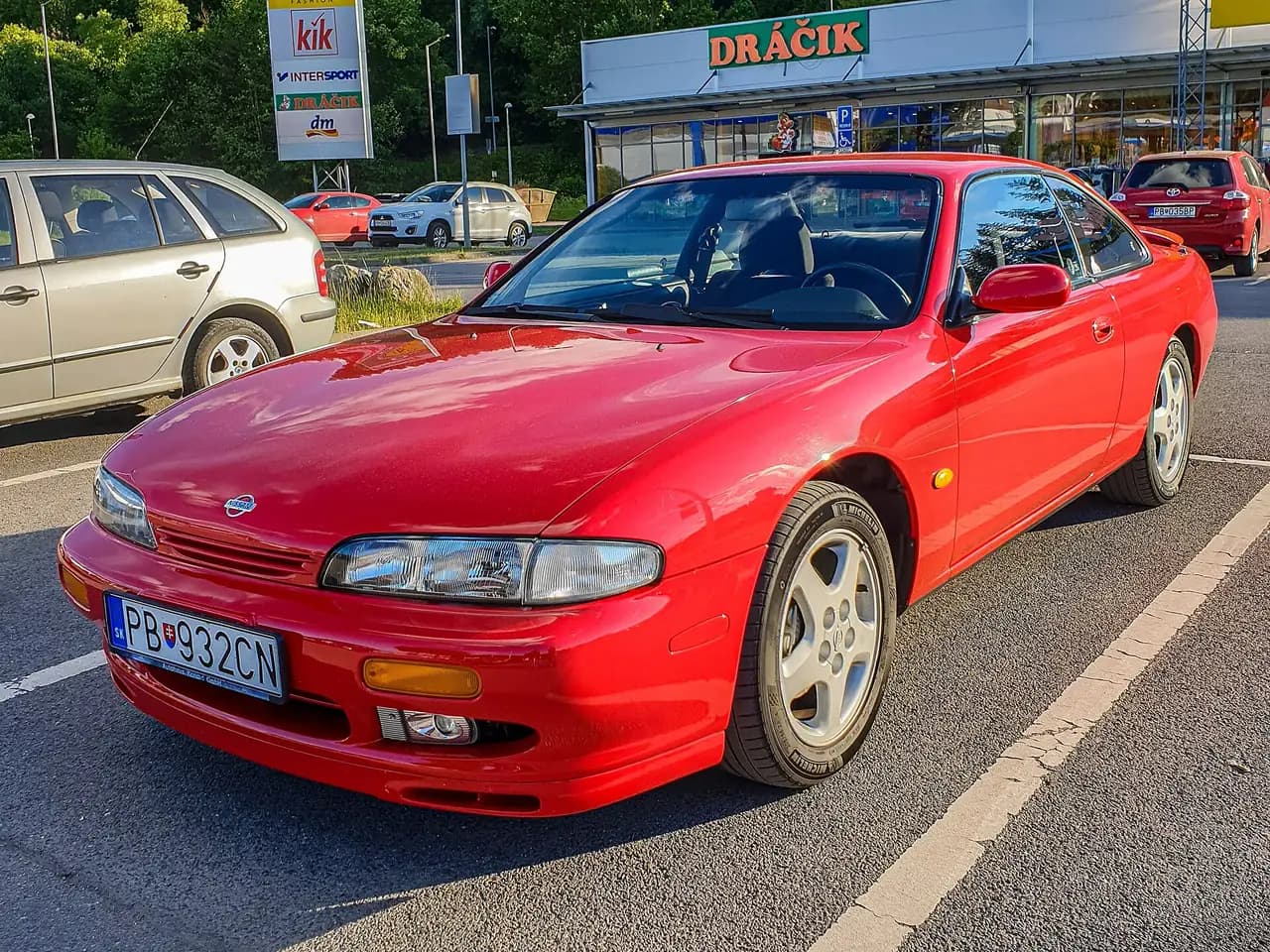 Red Nissan 200SX (S14, pre-facelift) coupe, front three-quarter view