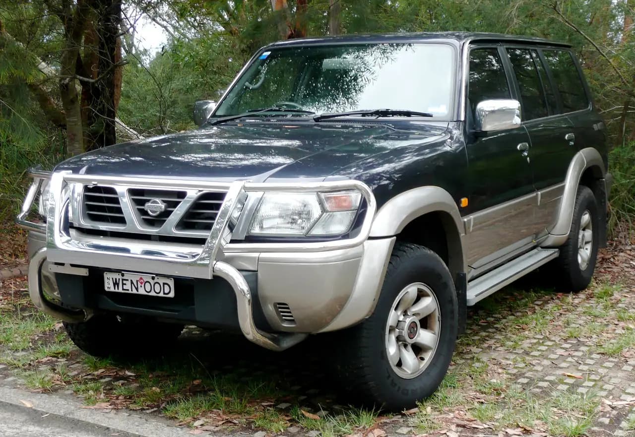 Dark blue two-tone 1997-2000 Nissan Patrol GU Ti wagon with nudge bar, front three-quarter view