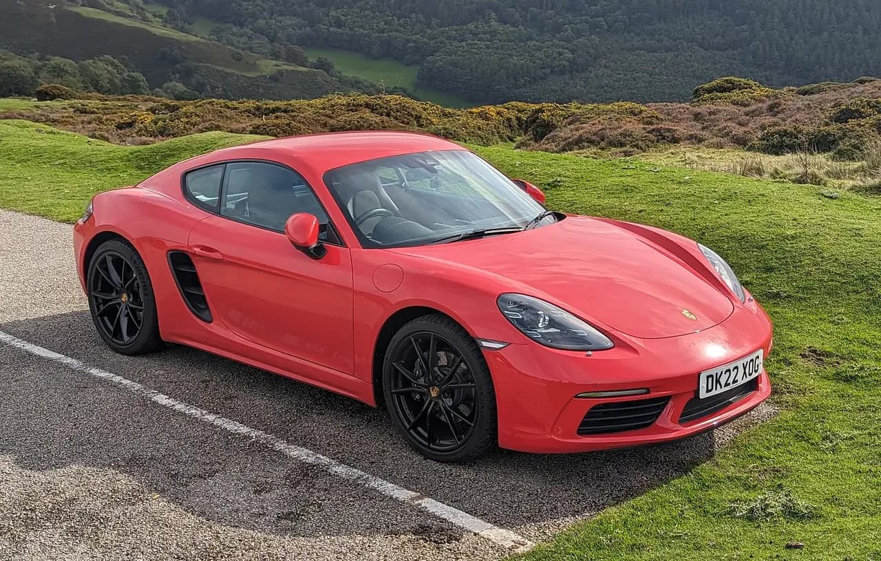 Red 2022 Porsche 718 Cayman (982) coupe, front three-quarter view