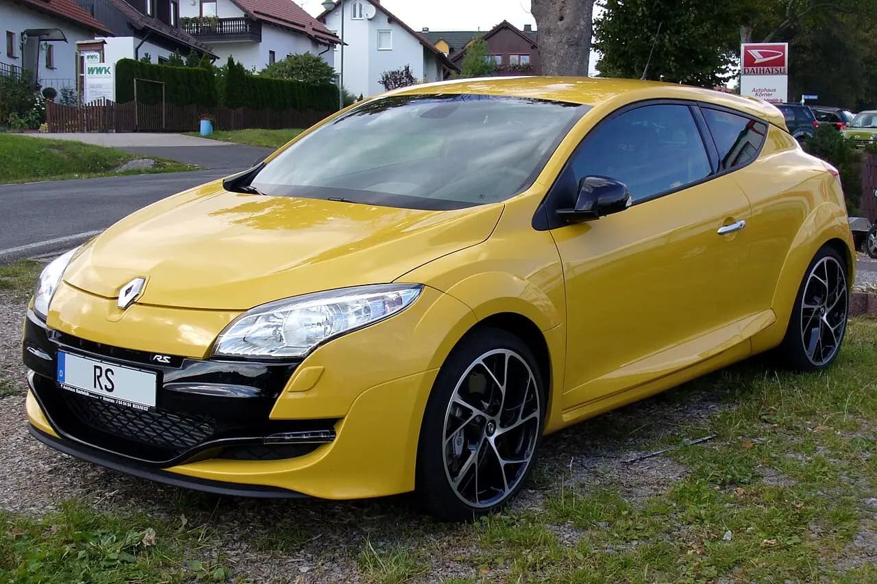 Yellow 2010 Renault Megane R.S. 250 (Mk3 pre-facelift) coupe, front three-quarter view