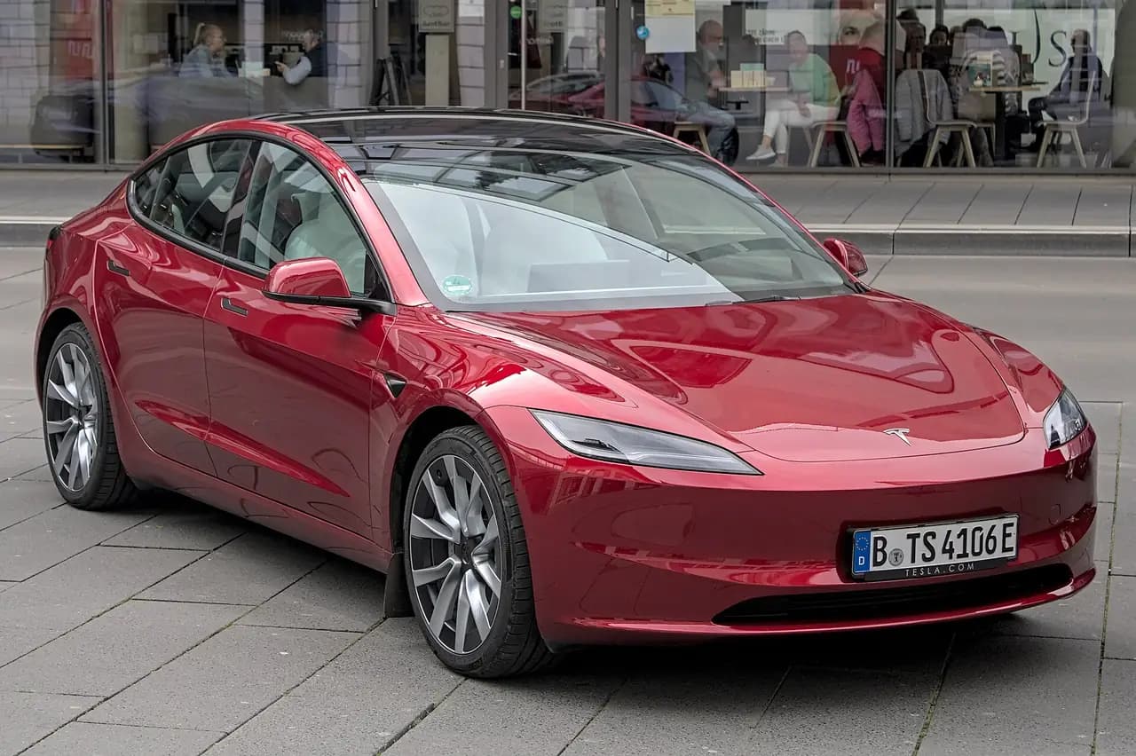 Red Tesla Model 3 Highland sedan, front three-quarter view