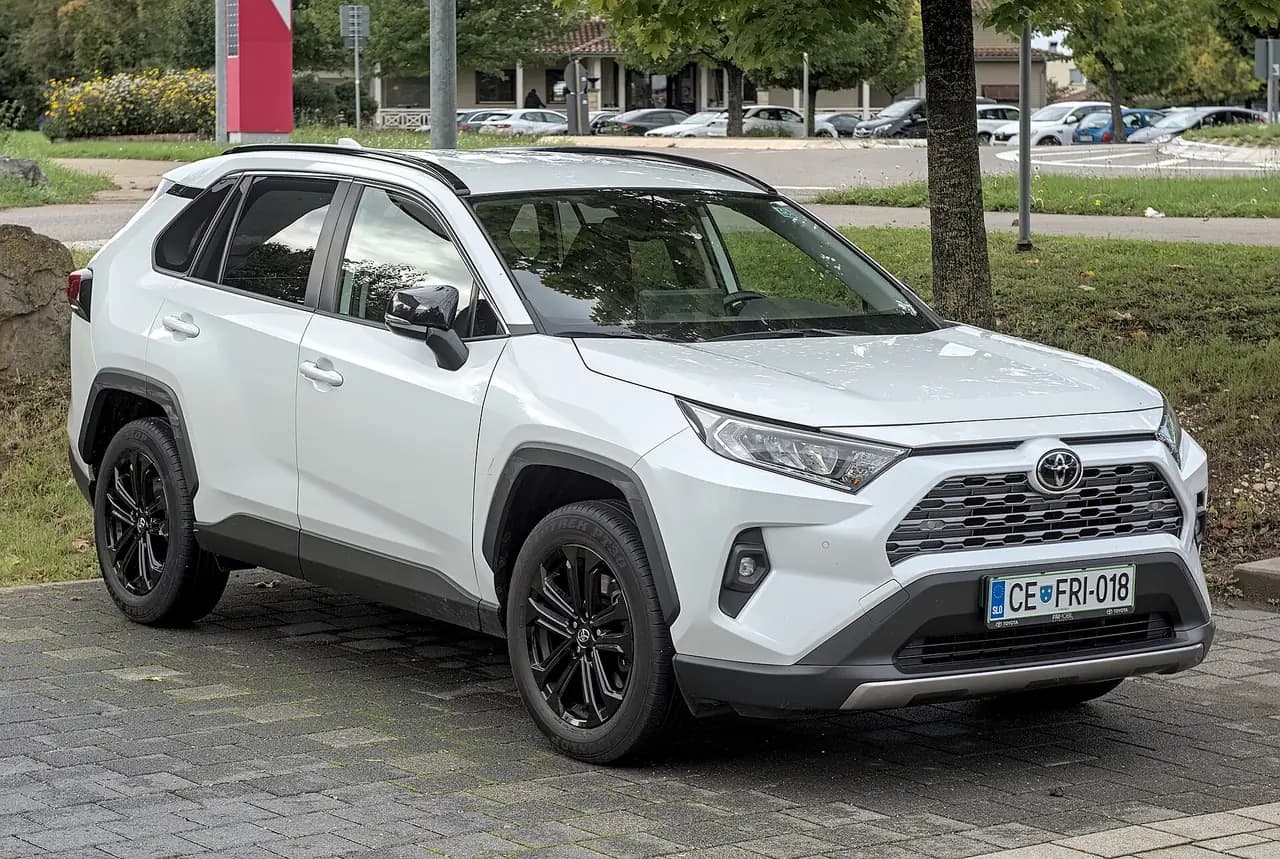 White Toyota RAV4 Hybrid (XA50) with black alloy wheels, front three-quarter view