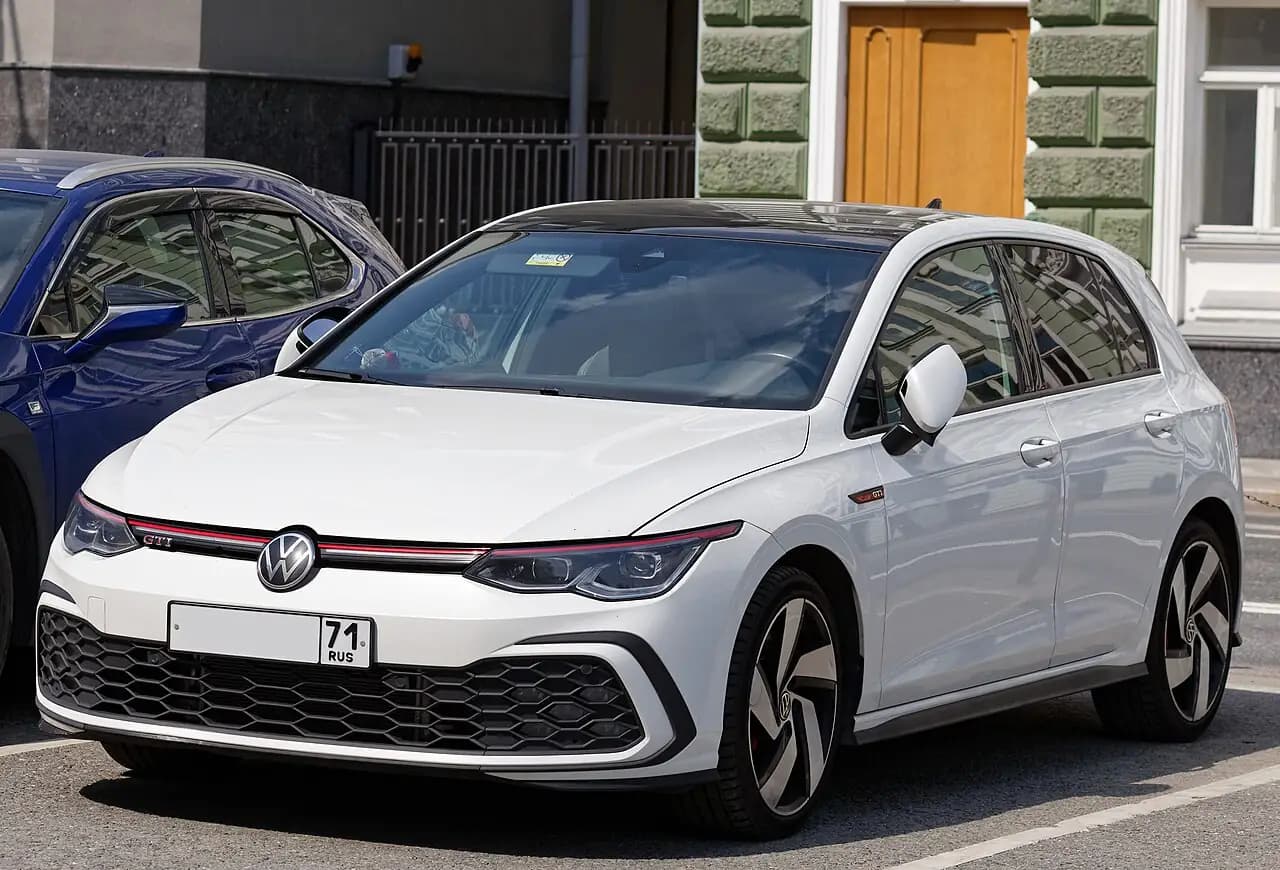 White pre-facelift Volkswagen Golf GTI (Mk8) hatchback, front three-quarter view